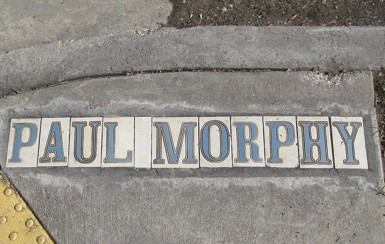 A series of decorative tiles spelling "PAUL MORPHY" laid out on a sidewalk. A series of decorative tiles spelling "PAUL MORPHY" laid out on a sidewalk.