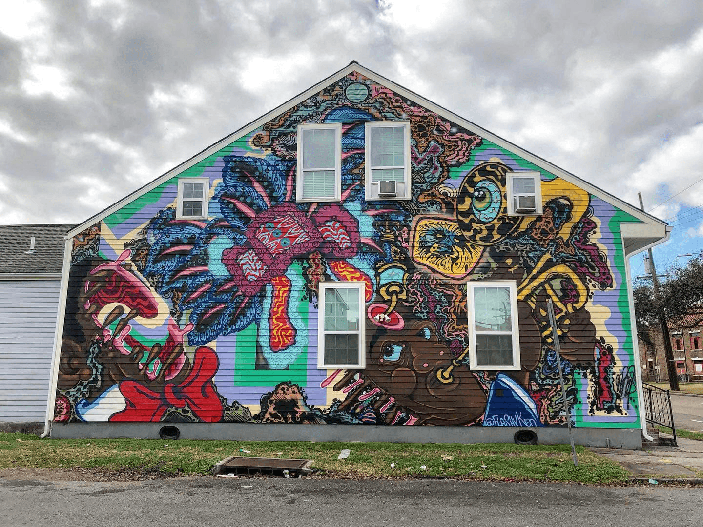 A colorful mural depicting abstract figures and animals covers the side of a house.
